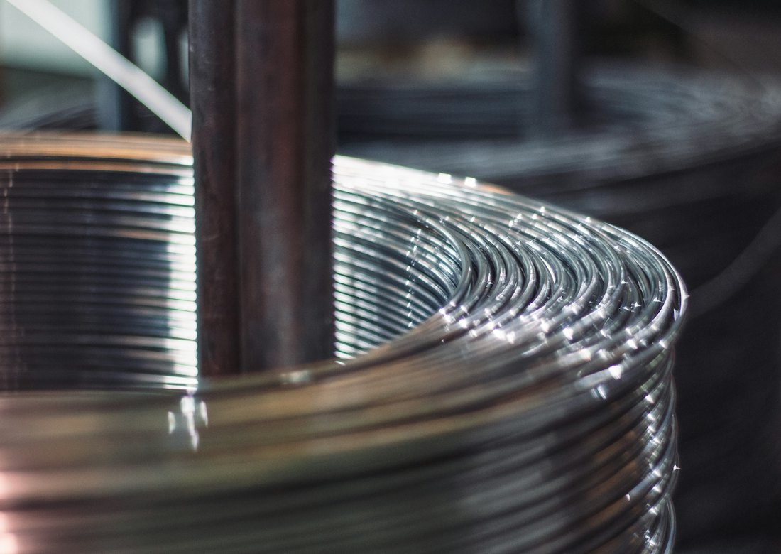 Close-up of a tightly wound coil of bright aluminium wire